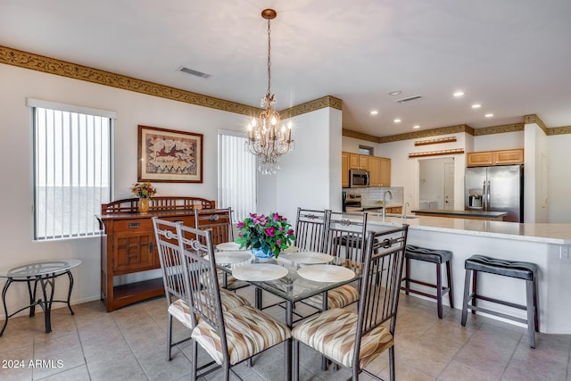 dining space with light tile patterned floors, sink, and an inviting chandelier