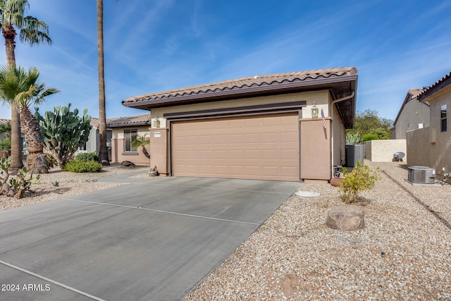 exterior space with central AC and a garage