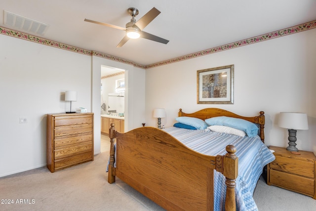 carpeted bedroom with ensuite bathroom and ceiling fan