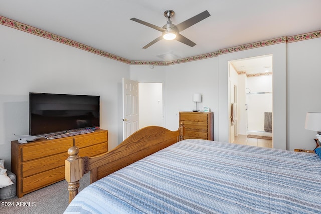 bedroom featuring light colored carpet, ensuite bath, and ceiling fan