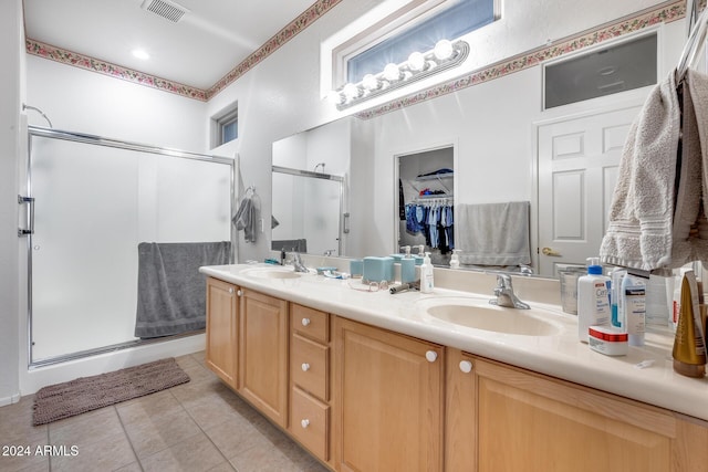 bathroom with tile patterned flooring, vanity, and an enclosed shower