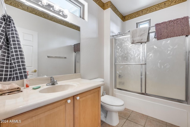 full bathroom with combined bath / shower with glass door, vanity, tile patterned floors, and a healthy amount of sunlight