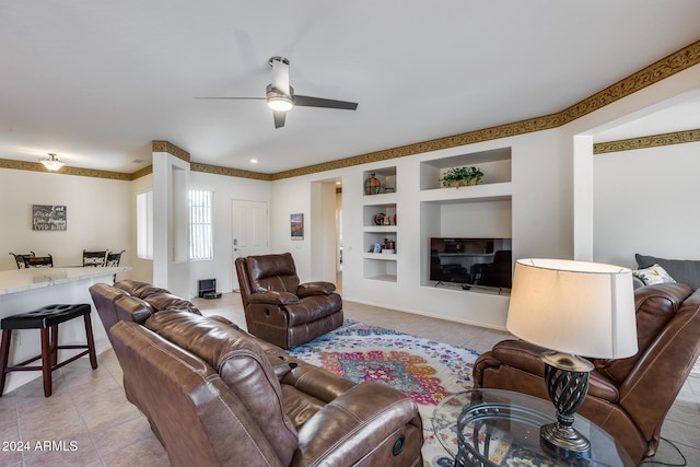 living room featuring built in shelves, ceiling fan, and light tile patterned flooring