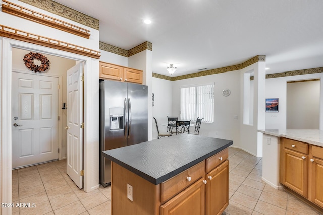 kitchen featuring a center island, dark stone countertops, stainless steel fridge with ice dispenser, and light tile patterned floors