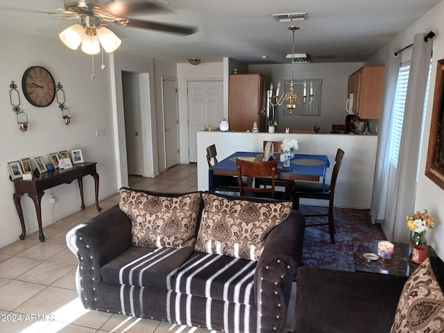 tiled living room featuring ceiling fan with notable chandelier