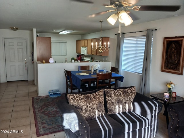 dining space with ceiling fan with notable chandelier and light tile patterned flooring