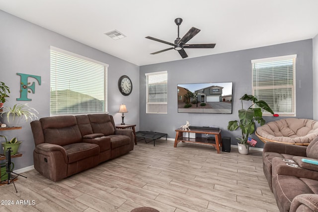 living room with light hardwood / wood-style flooring, ceiling fan, and a healthy amount of sunlight