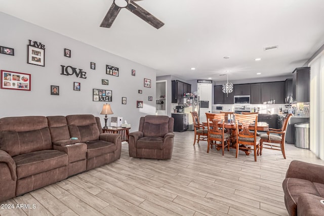 living room featuring ceiling fan and light hardwood / wood-style floors