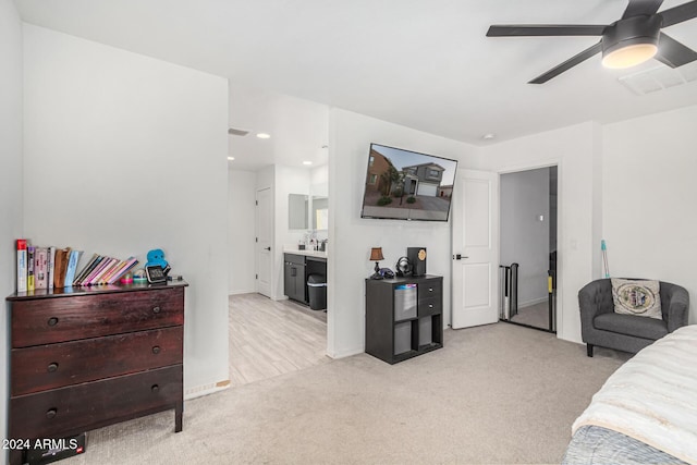 carpeted bedroom featuring ceiling fan and ensuite bath