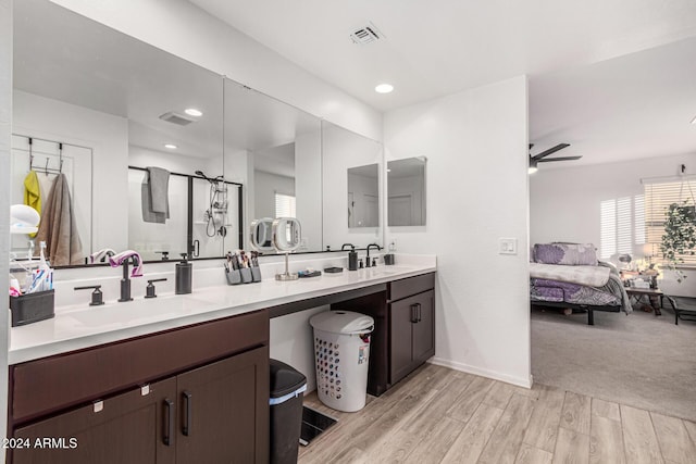 bathroom with vanity, a shower with door, and ceiling fan