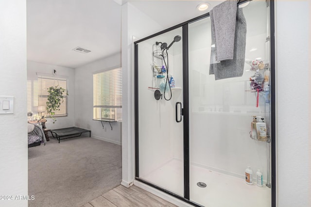 bathroom featuring a shower with door