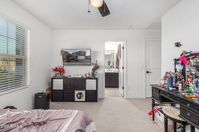 carpeted bedroom featuring ensuite bath and ceiling fan