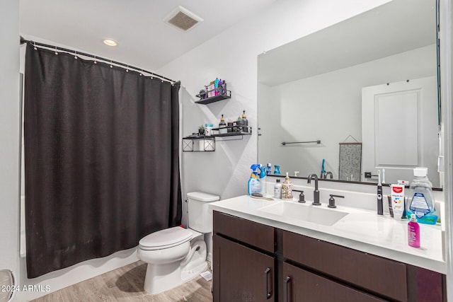 full bathroom with hardwood / wood-style floors, vanity, toilet, and shower / bathtub combination with curtain