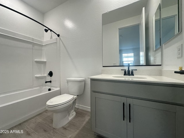 full bathroom with toilet, wood finished floors, tub / shower combination, baseboards, and vanity