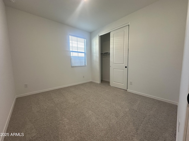 unfurnished bedroom with a closet, carpet, and baseboards