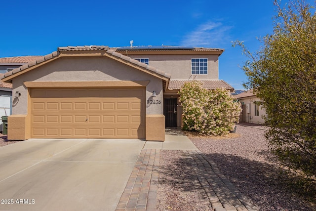 12426 W Surrey Ave, El Mirage, AZ 85335 - view of front of house featuring a garage, stucco siding, solar panels, and a tile roof