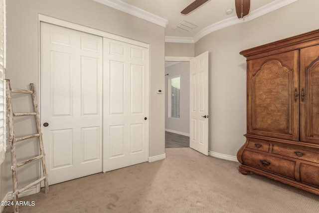 unfurnished bedroom featuring crown molding, light colored carpet, a closet, and ceiling fan