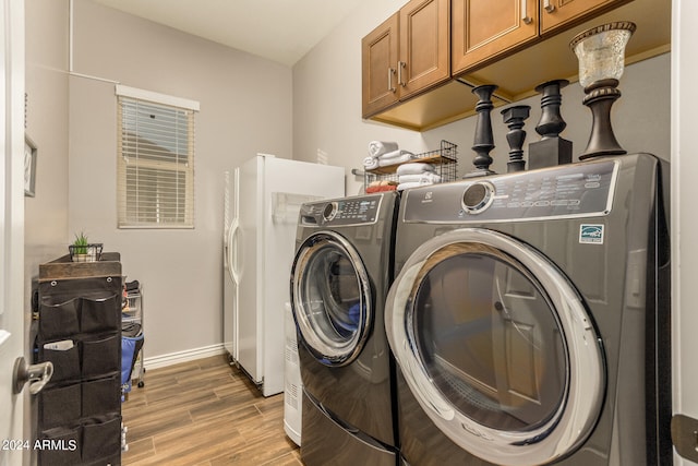 laundry area with independent washer and dryer, cabinets, and light hardwood / wood-style flooring