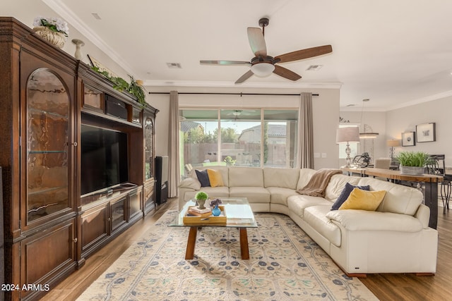 living room with ornamental molding, hardwood / wood-style floors, and ceiling fan