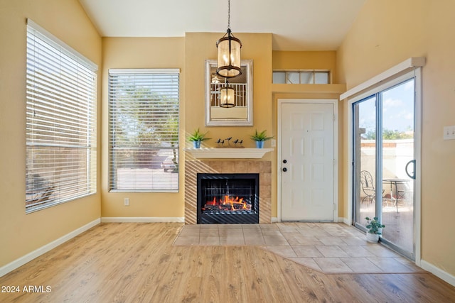 unfurnished living room featuring plenty of natural light, light hardwood / wood-style floors, and a tile fireplace