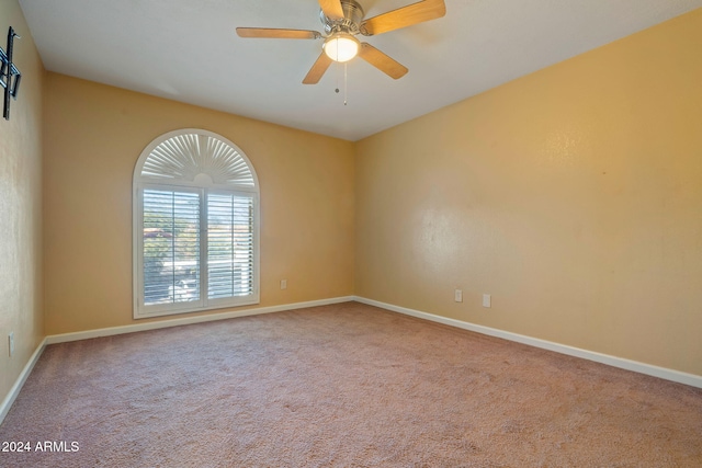 carpeted spare room with ceiling fan