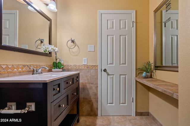 bathroom with tile patterned flooring, vanity, and tile walls