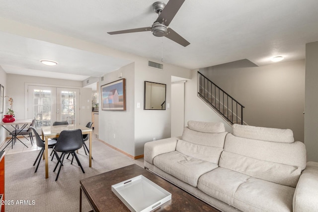 carpeted living room with ceiling fan and french doors