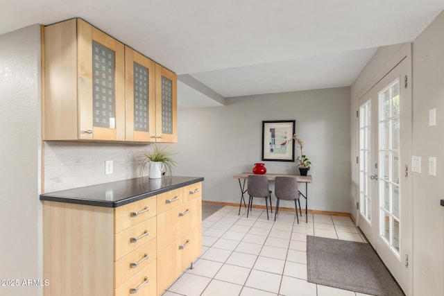 kitchen featuring tasteful backsplash, light tile patterned floors, and light brown cabinets