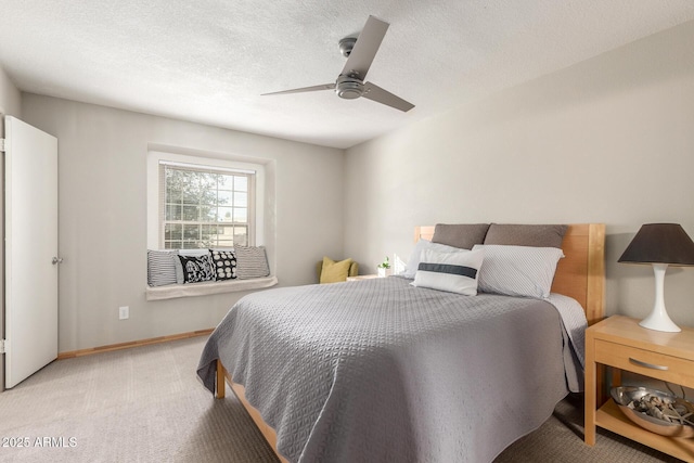 carpeted bedroom with ceiling fan and a textured ceiling