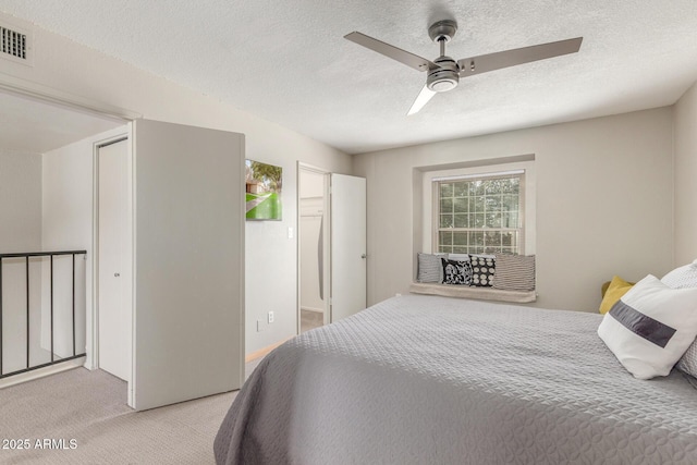 carpeted bedroom featuring a textured ceiling and ceiling fan