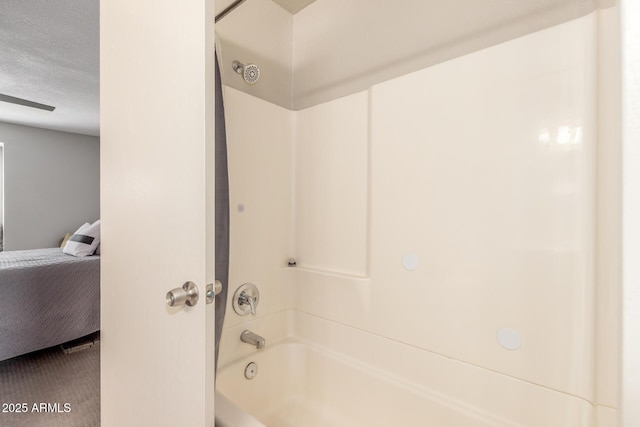 bathroom with shower / washtub combination and a textured ceiling