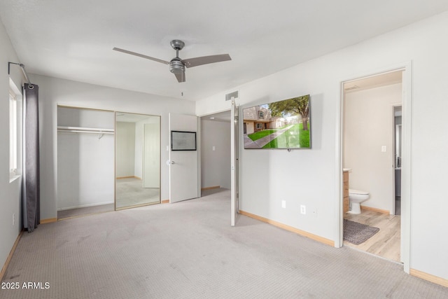 unfurnished bedroom featuring connected bathroom, light colored carpet, a closet, and ceiling fan