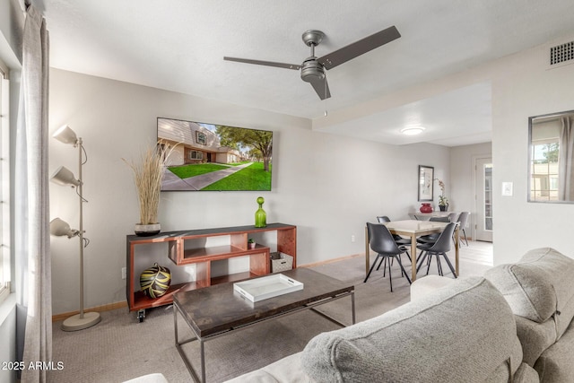 carpeted living room with ceiling fan