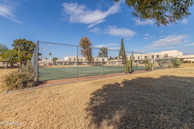 view of tennis court featuring a lawn