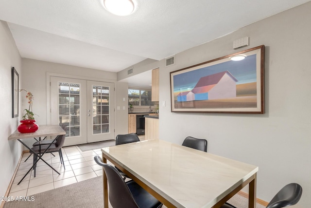 dining room featuring light tile patterned floors and french doors