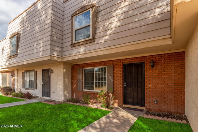 property entrance with a lawn