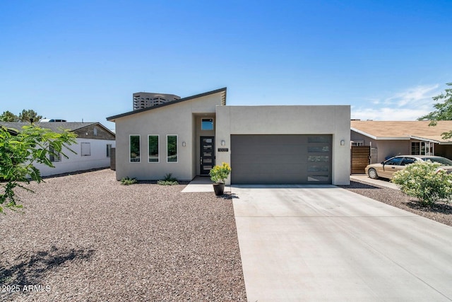 1005 E Weldon Ave, Phoenix, AZ 85014 - modern home featuring an attached garage, driveway, and stucco siding