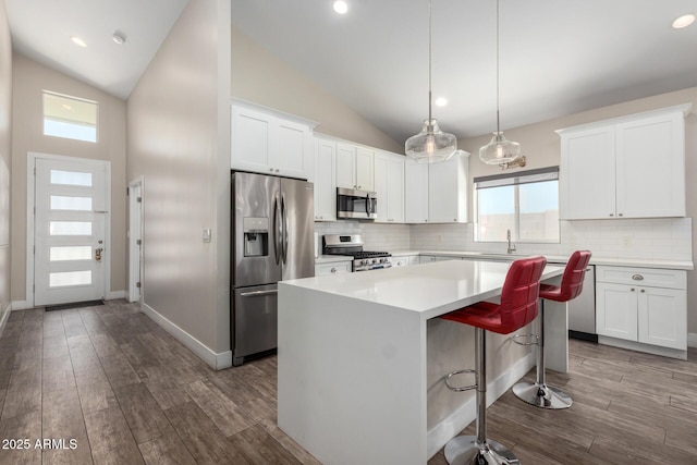 1005 E Weldon Ave, Phoenix, AZ 85014 - kitchen featuring stainless steel appliances, vaulted ceiling, a sink, a center island, and tasteful backsplash