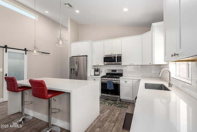 1005 E Weldon Ave, Phoenix, AZ 85014 - kitchen with stainless steel appliances, a sink, dark wood-style floors, a center island, and decorative backsplash