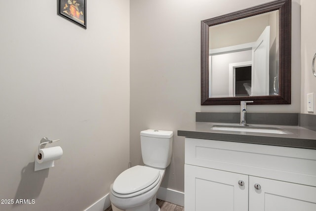 1005 E Weldon Ave, Phoenix, AZ 85014 - half bath featuring toilet, vanity, baseboards, and wood finished floors