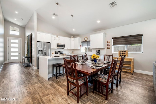 1005 E Weldon Ave, Phoenix, AZ 85014 - dining room featuring wood finished floors, baseboards, and high vaulted ceiling