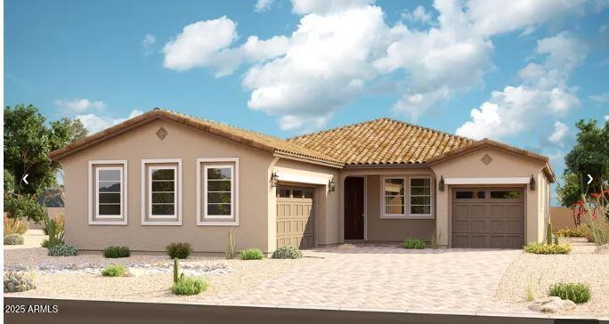 mediterranean / spanish-style home featuring stucco siding, a tile roof, a garage, and decorative driveway