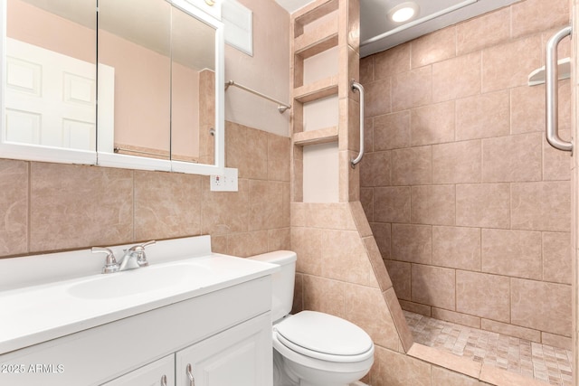 bathroom featuring tile walls, backsplash, a tile shower, vanity, and toilet