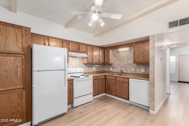 kitchen with backsplash, white appliances, light hardwood / wood-style floors, and sink