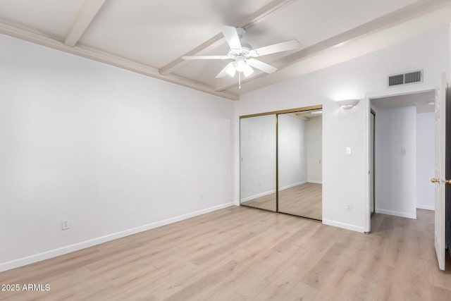 unfurnished bedroom featuring ceiling fan, light hardwood / wood-style floors, a closet, and vaulted ceiling with beams