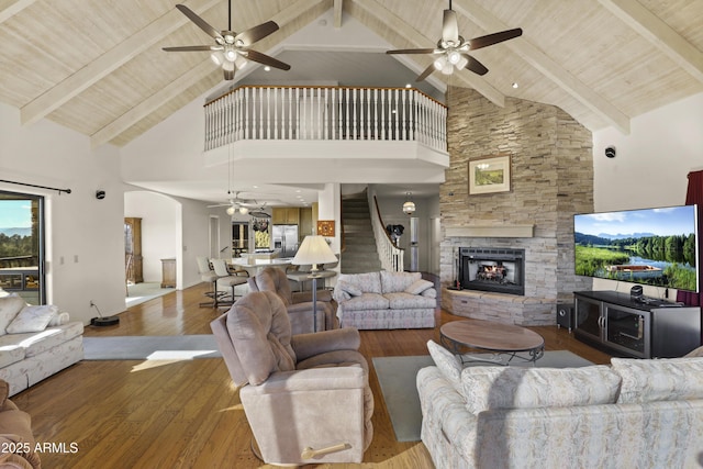 living room with a fireplace, hardwood / wood-style floors, high vaulted ceiling, and beamed ceiling