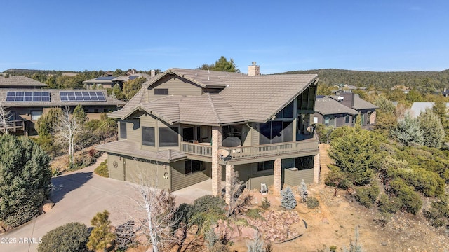 rear view of property featuring a balcony and a garage