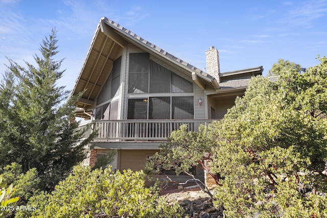 rear view of property with a sunroom and a garage