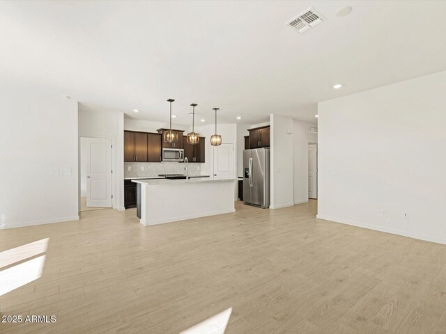 unfurnished living room with sink and light wood-type flooring