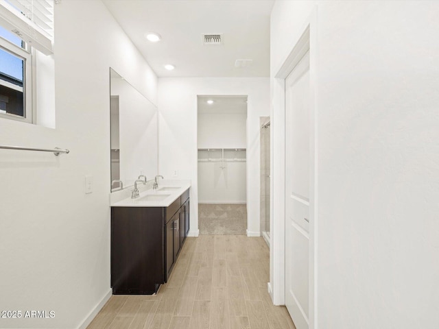 bathroom with a shower with door and vanity